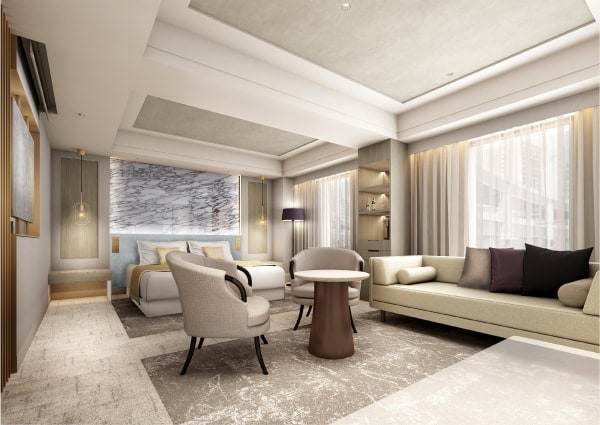 A modern hotel room with a double bed, two armchairs around a small table, a beige sofa, large windows with sheer curtains, and elegant decor in neutral tones with marble and wood accents.
