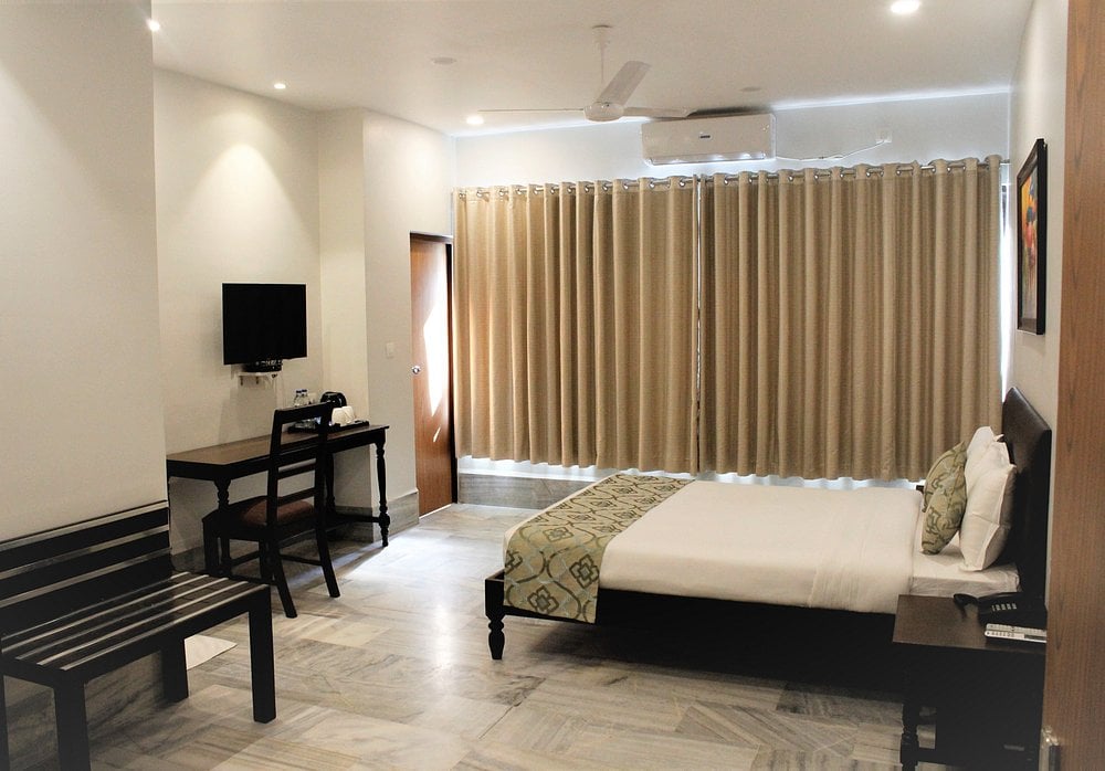 A hotel room with a bed, chair and table