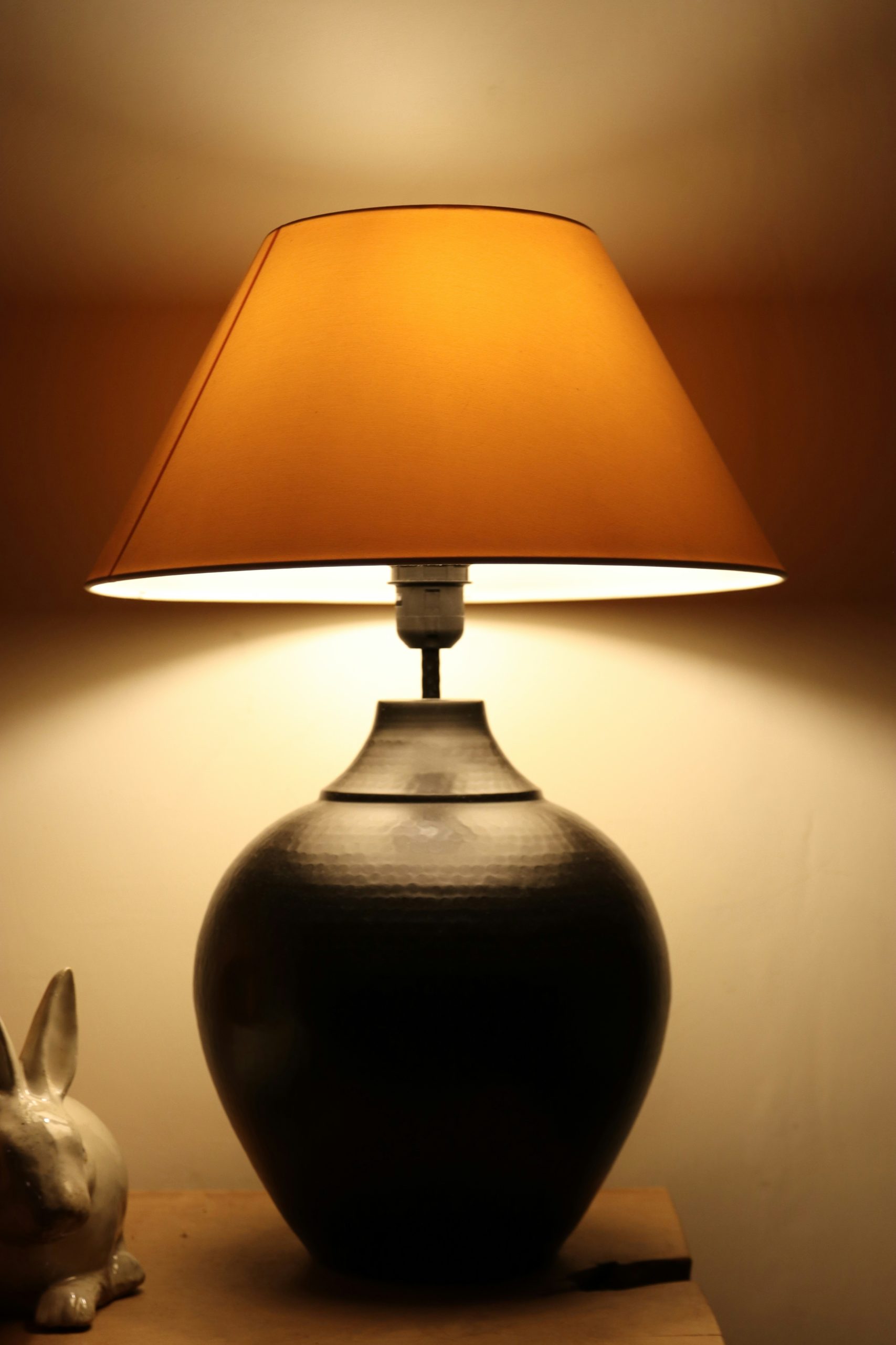 Table lamp casting warm amber light against a dark background